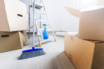 Empty room full of cardboard boxes and cleaning things for moving into a new home