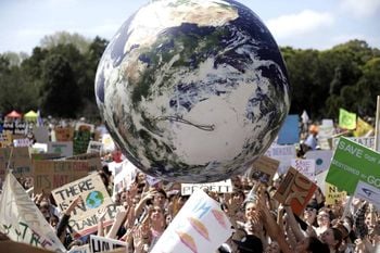 A large inflatable globe is bounced through the crowd as thousands of protesters join a climate change rally in Sydney (Rick Rycroft/AP)