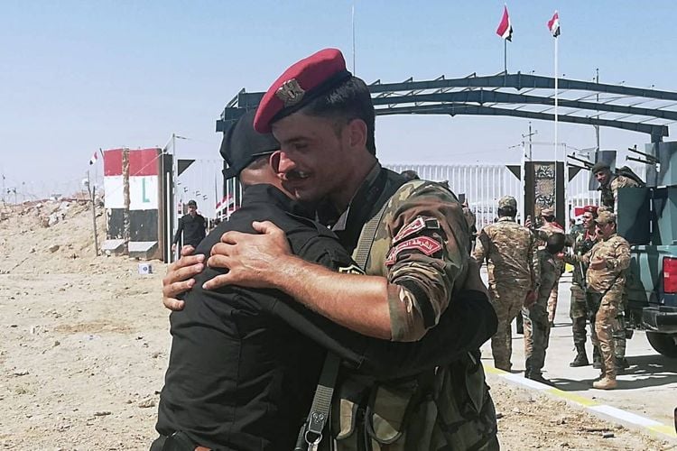 Iraq and Syria border guards soldiers congratulate each other during the opening ceremony of the crossing between the Iraqi town of Qaim and Syria's Boukamal in Anbar province, Iraq, Monday, Sept. 30, 2019. Iraq and Syria have opened a key border crossing between the two neighboring countries seven years after it was closed during Syria's civil war. (AP Photo/Hadi Mizban)