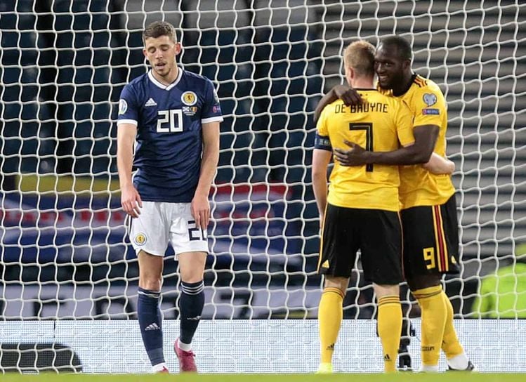 Scotland's Ryan Christie (left) after Belgium's Romelu Lukaku celebrates scoring his side's first goal of the game with Kevin De Bruyne during the UEFA Euro 2020 qualifying group I match at Hampden Park, Glasgow.