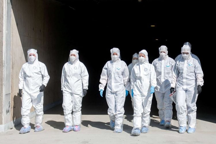 File photo of a Covid19 drive through testing station in Gdansk, Poland. The PPE being worn by the testers is body suit, face visor, respirator, fett coverings and gloves. See SWNS story SWOCppe A comparison with pictures from other country's drive through testing stations seems to indicate that PPE standards in the UK offer less protection.