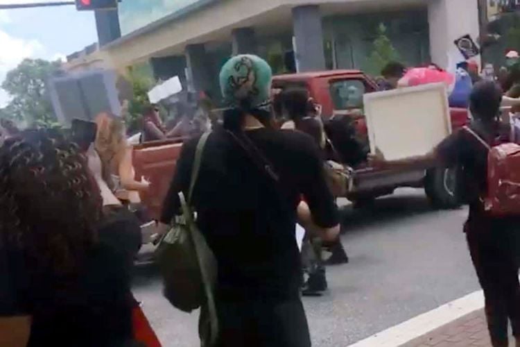 In this image taken from from video provided by @alexisnscott._, a pickup truck drives through a crowd of protesters, Saturday, May 30, 2020, in Tallahassee, Fla Tallahassee police said Saturday that the driver was in custody and that no one was seriously injured.  (@alexisnscott._ via AP)