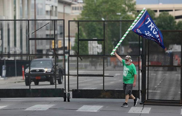 Mike Pellerin waves a Donald Trump campaign flag near a barricade after driving  all night from Austin, Tx. to line up and camp with other Trump supporters on 4th Street and Cheyenne Ave. in downtown Tulsa ahead of Saturday's campaign rally Friday, June 19, 2020. The area for several blocks around the BOK Center is barricaded. Upon arriving Pellerin said he needed to burn some energy before taking a nap. MIKE SIMONS/Tulsa World