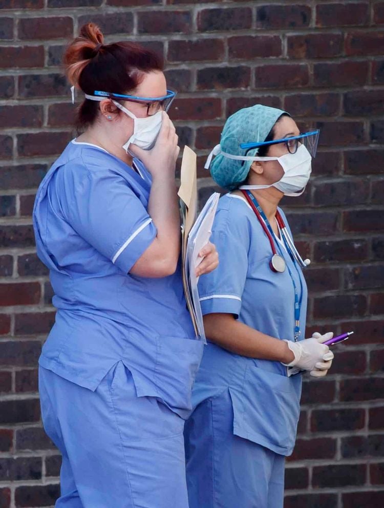 Hospital staff wear face masks outside Doncaster Royal Infirmary, as organisations representing hospital trusts have rounded on the Government over its promise of more personal protective equipment (PPE) to protect workers in the fight against Covid-19.