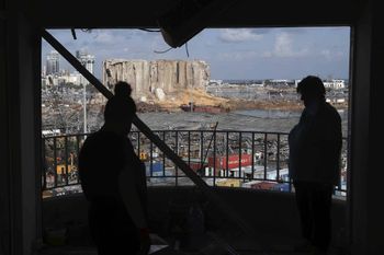 Women stand in their damaged house as they look at the aftermath of an explosion that hit the seaport of Beirut, Lebanon, Monday, Aug. 10, 2020. World leaders and international organizations pledged nearly $300 million in emergency humanitarian aid to Beirut in the wake of the devastating explosion, but warned on Sunday that no money for rebuilding the capital will be made available until Lebanese authorities commit themselves to the political and economic reforms demanded by the people. (AP Photo/Bilal Hussein)