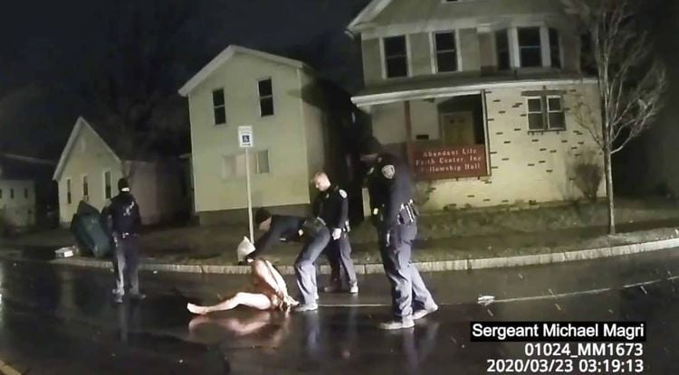 In this image taken from police body camera video provided by Roth and Roth LLP, a Rochester police officer puts a hood over the head of Daniel Prude, on March 23, 2020, in Rochester, N.Y. Video of Prude, a Black man who had run naked through the streets of the western New York city, died of asphyxiation after a group of police officers put a hood over his head, then pressed his face into the pavement for two minutes, according to video and records released Wednesday, Sept. 2, 2020, by his family. Prude died March 30 after he was taken off life support, seven days after the encounter with police in Rochester. (Rochester Police via Roth and Roth LLP via AP)