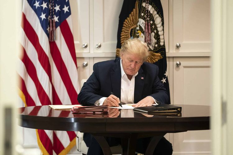 In this image released by the White House, President Donald Trump works in the Presidential Suite at Walter Reed National Military Medical Center in Bethesda, Md. Saturday, Oct. 3, 2020, after testing positive for COVID-19. (Joyce N. Boghosian/The White House via AP)