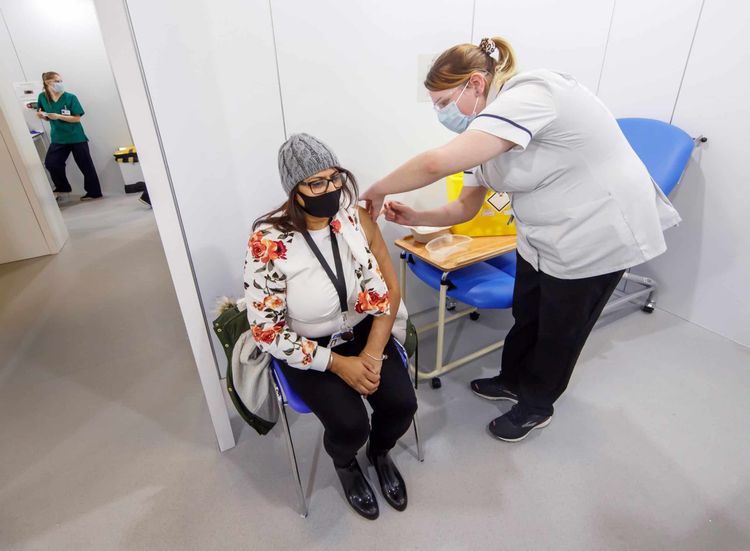 A woman receives an injection of the the Oxford/AstraZeneca coronavirus vaccine at Elland Road vaccine centre in Leeds, as a study shows that people from Asian and minority ethnic (BAME) groups living in deprived communities are more likely to be hesitant about the coronavirus vaccine than those in more affluent areas. Picture date: Friday March 12, 2021.