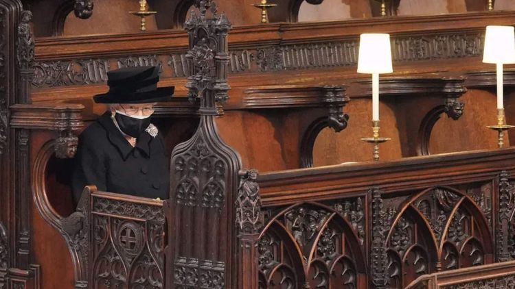 The Queen sitting alone whilst wearing a mask at her late husband Prince Philip's funeral. Photo: PA.