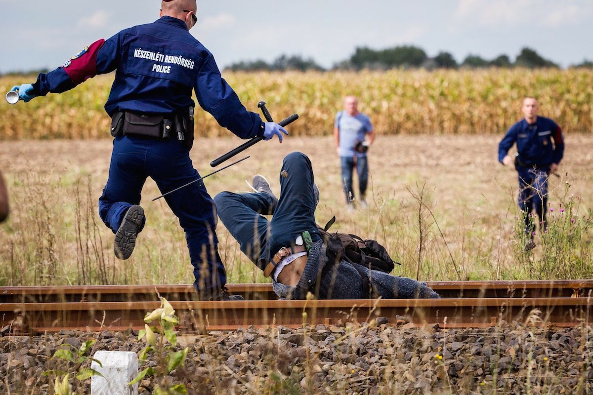 SWNS Pictures of the Year 2015 - One hundred of the most compelling images on the SWNS wire this year as chosen by our picture editors. Hundreds of migrants break out of a holding area and run away from police in Roszke, Hungary. 08 September 2015.