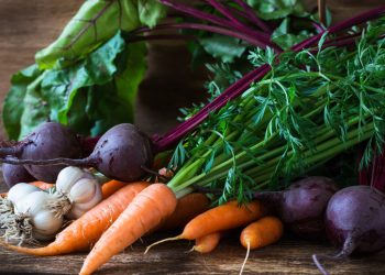 Bunch of fresh organic beetroots, garlic and carrots on wooden rustic table, different types of root vegetables