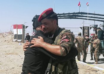 Iraq and Syria border guards soldiers congratulate each other during the opening ceremony of the crossing between the Iraqi town of Qaim and Syria's Boukamal in Anbar province, Iraq, Monday, Sept. 30, 2019. Iraq and Syria have opened a key border crossing between the two neighboring countries seven years after it was closed during Syria's civil war. (AP Photo/Hadi Mizban)