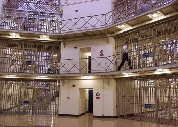 File photo dated 30/03/00 of a prison officer in the Rotunda area of HMP Manchester. The prison has been assessed by inspectors as having made slow and weak progress in many key areas where improvement was urged after a full inspection in 2018.