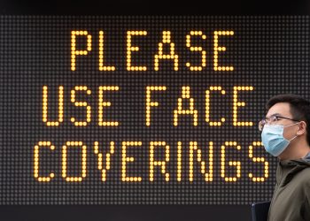 Embargoed to 0001 Thursday August 20 File photo dated 09/06/20 of a man wearing a protective face mask walking past signage advising the use of face coverings. Medical jargon surrounding masks may put some people off using face coverings, a new paper suggests.