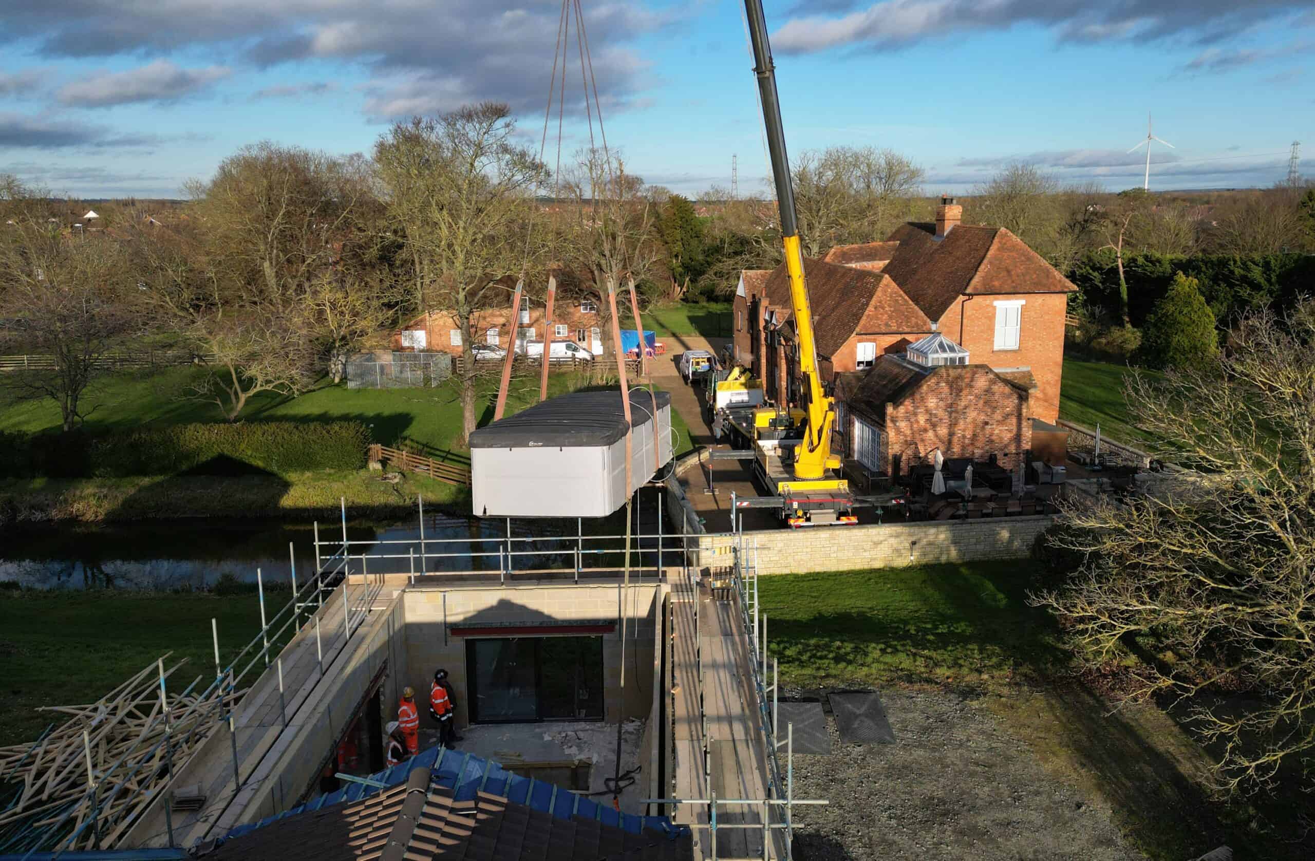 Crane lifts massive swimming pool out of spa block at home of Captain Tom’s family